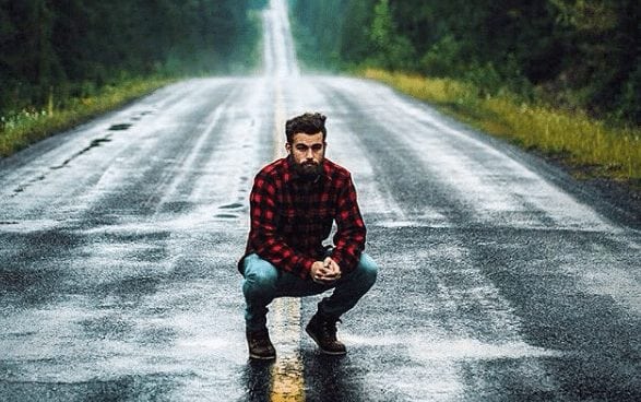 lumbersexual look man in red flannel shirt jeans