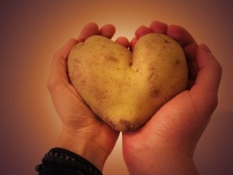 man and woman holding a heart shaped potato