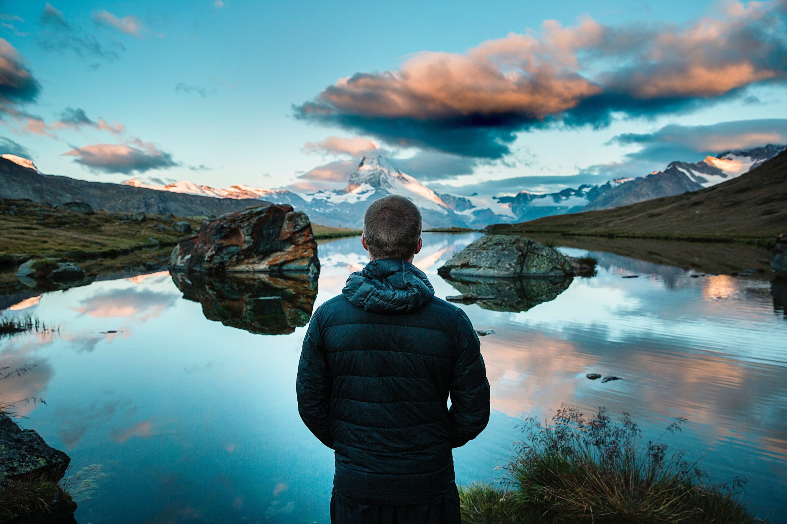 man looking across the lake into the mountains