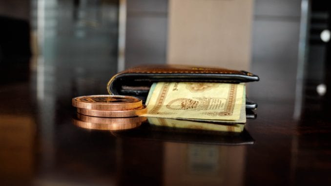 leather wallet next to ring with money