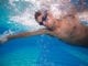 man swimming underwater athletic